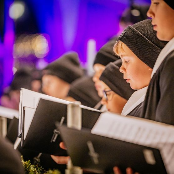 Chorknaben mit Notenbüchern beim Singen.